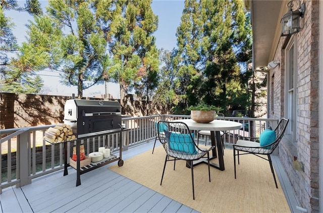 wooden deck featuring grilling area and outdoor dining space