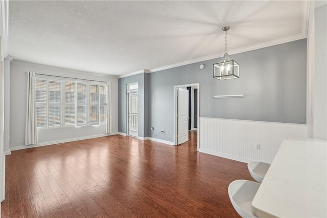 1101 Juniper St NE Unit 415, Atlanta, GA 30309 - unfurnished dining area featuring a chandelier, wood finished floors, ornamental molding, a textured ceiling, and a wainscoted wall