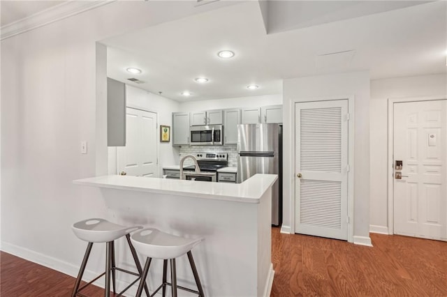 1101 Juniper St NE Unit 415, Atlanta, GA 30309 - kitchen featuring appliances with stainless steel finishes, a kitchen breakfast bar, baseboards, dark wood-type flooring, and recessed lighting