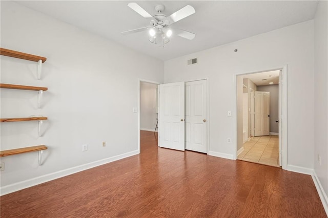1101 Juniper St NE Unit 415, Atlanta, GA 30309 - unfurnished bedroom featuring wood finished floors, baseboards, and a ceiling fan