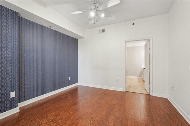 1101 Juniper St NE Unit 415, Atlanta, GA 30309 - unfurnished room with an accent wall, ceiling fan, wood finished floors, baseboards, and wallpapered walls