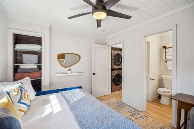 101 Evening Shade, Clayton, GA 30525 - bedroom featuring light wood finished floors, baseboards, ornamental molding, connected bathroom, and stacked washer and dryer