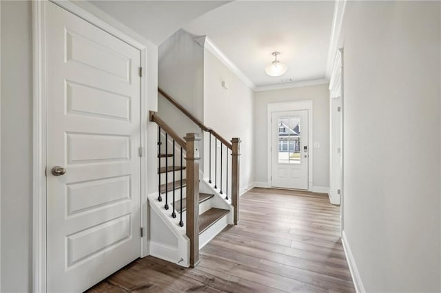 foyer with ornamental molding and light wood-type flooring