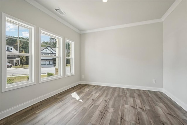 empty room with crown molding and wood-type flooring