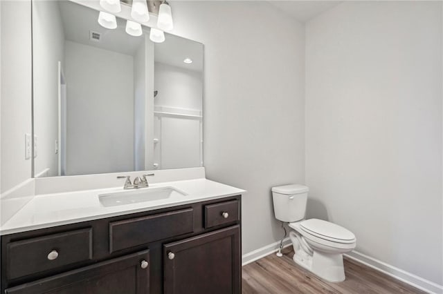 bathroom featuring toilet, hardwood / wood-style flooring, and vanity