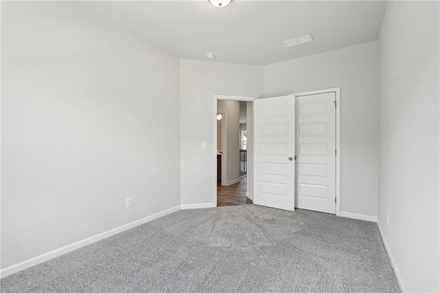 unfurnished bedroom with a closet and dark colored carpet