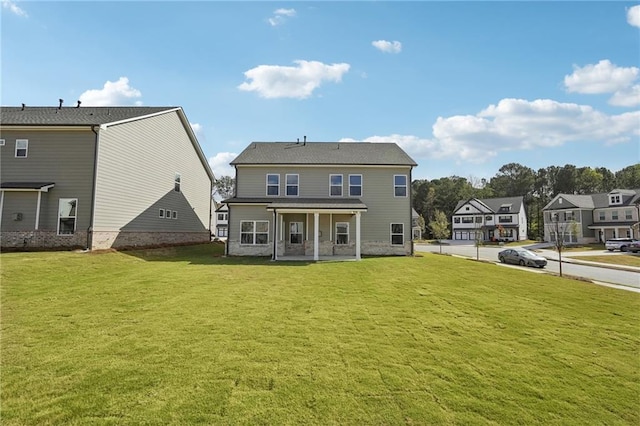 back of property with a yard and covered porch