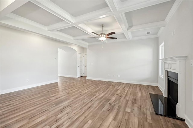 unfurnished living room with ceiling fan, ornamental molding, beamed ceiling, light hardwood / wood-style floors, and coffered ceiling