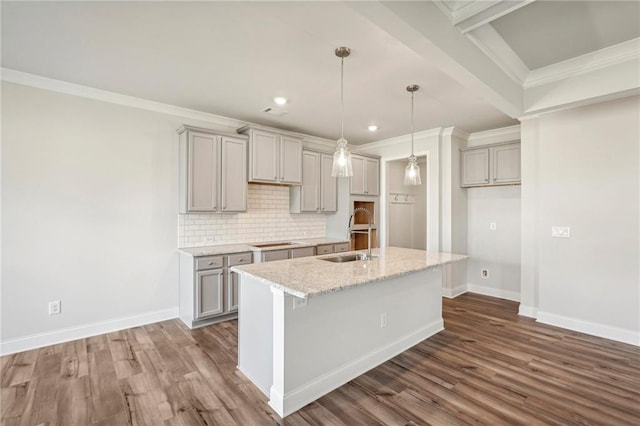 kitchen featuring gray cabinetry, ornamental molding, sink, light stone countertops, and dark hardwood / wood-style flooring