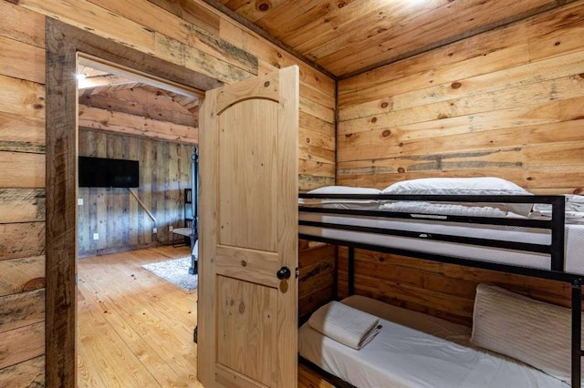 bedroom with hardwood / wood-style flooring, wooden walls, and wood ceiling