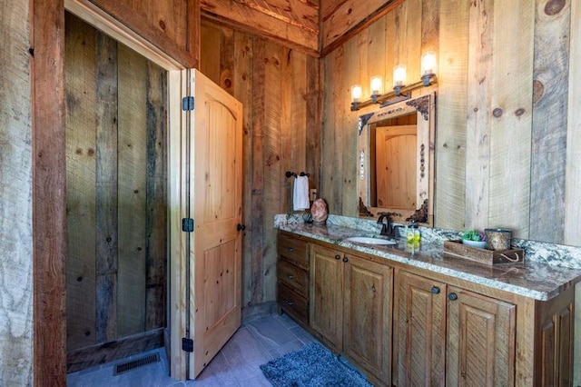 bathroom with wood walls and vanity