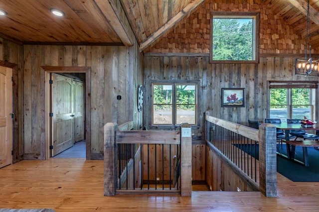 hall featuring lofted ceiling with beams, wood walls, wood-type flooring, and wood ceiling