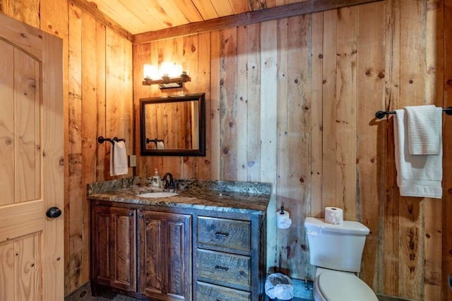 bathroom featuring vanity, toilet, wooden walls, and wood ceiling