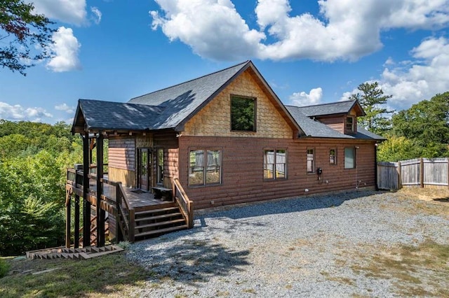 rear view of house featuring a wooden deck