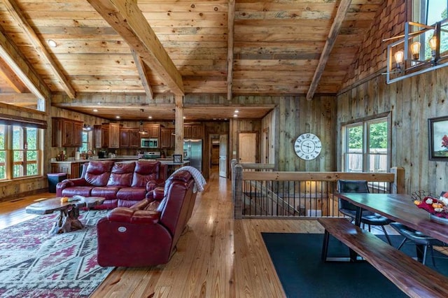 living room with plenty of natural light, light hardwood / wood-style floors, and wooden ceiling