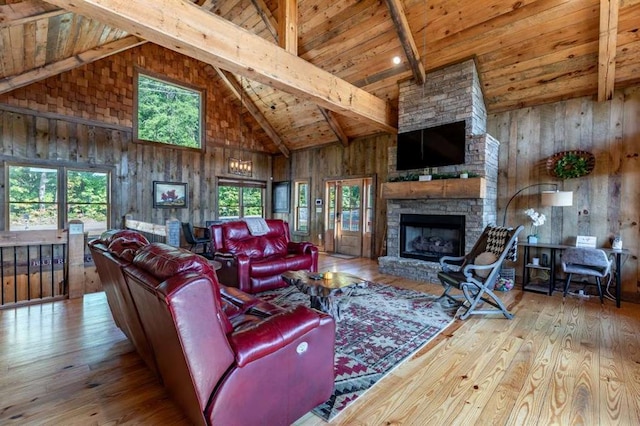 living room with beamed ceiling, light hardwood / wood-style flooring, plenty of natural light, and a fireplace