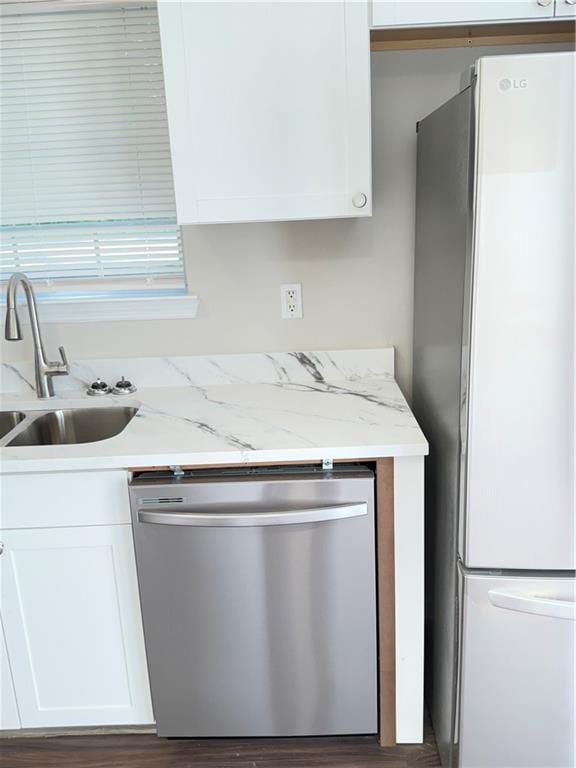 2115 Charter Ln, Lithonia, GA 30058 - kitchen with a sink, white cabinets, stainless steel dishwasher, and freestanding refrigerator