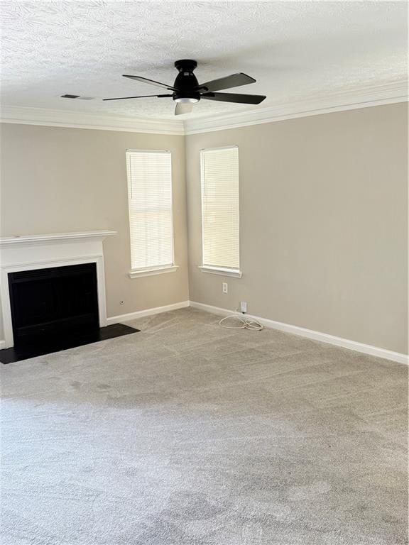2115 Charter Ln, Lithonia, GA 30058 - unfurnished living room with ornamental molding, ceiling fan, a fireplace with flush hearth, and baseboards