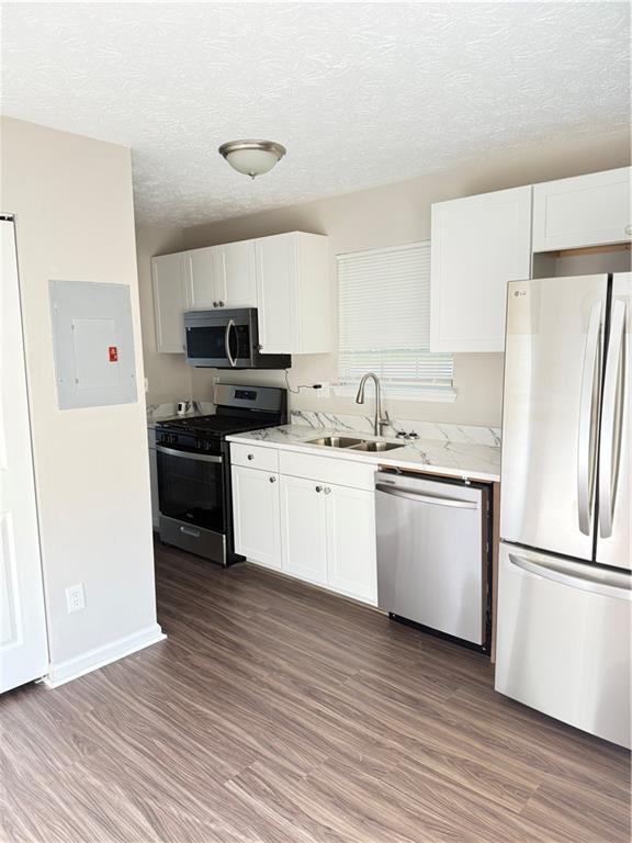 2115 Charter Ln, Lithonia, GA 30058 - kitchen with stainless steel appliances, wood finished floors, electric panel, and a sink