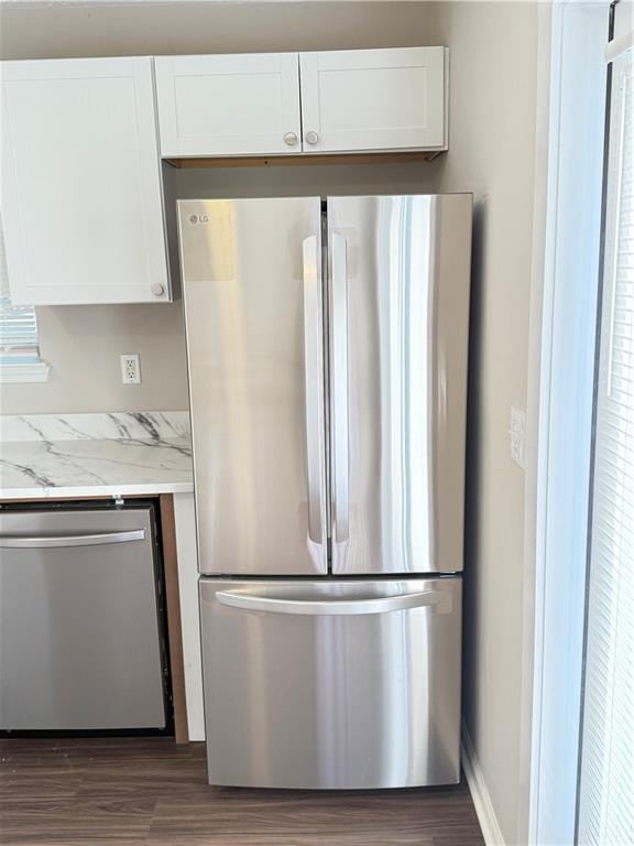 2115 Charter Ln, Lithonia, GA 30058 - kitchen featuring light stone countertops, appliances with stainless steel finishes, wood finished floors, and white cabinetry
