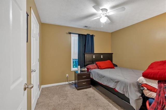 carpeted bedroom featuring a textured ceiling, visible vents, baseboards, and a ceiling fan