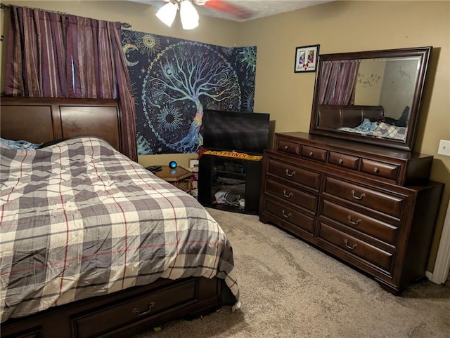 bedroom featuring light carpet and a ceiling fan