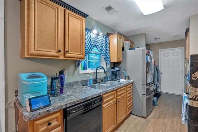 kitchen with visible vents, light wood-type flooring, a textured ceiling, a sink, and dishwasher