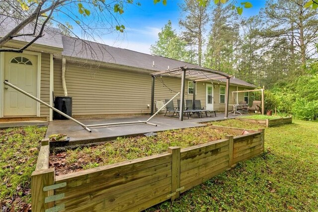 back of property featuring a garden, a patio, a yard, and a pergola