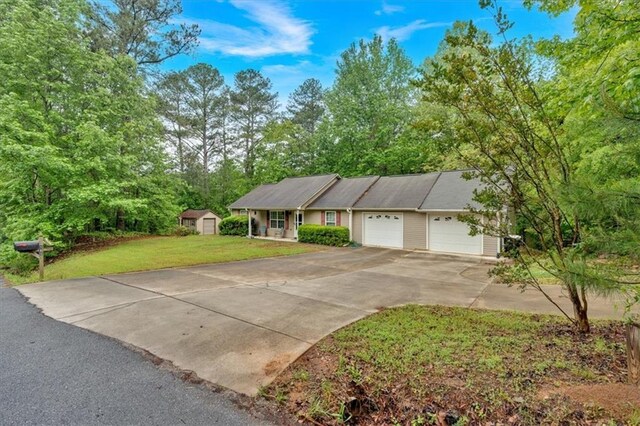 ranch-style house with a garage, a storage unit, driveway, and a front lawn