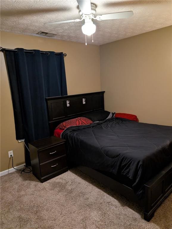 bedroom featuring ceiling fan, light colored carpet, a textured ceiling, and visible vents