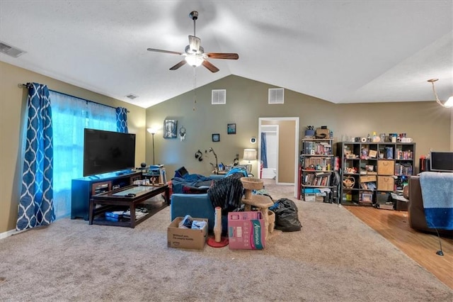 carpeted living area featuring a ceiling fan, lofted ceiling, and visible vents
