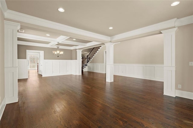 unfurnished living room with decorative columns, a chandelier, a decorative wall, wainscoting, and beamed ceiling