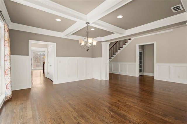 empty room with a chandelier, beamed ceiling, coffered ceiling, recessed lighting, and a wainscoted wall