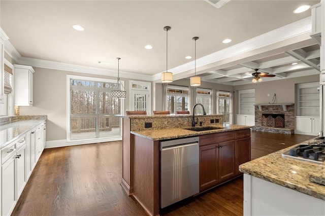 kitchen featuring stainless steel appliances, a sink, a ceiling fan, a fireplace, and plenty of natural light