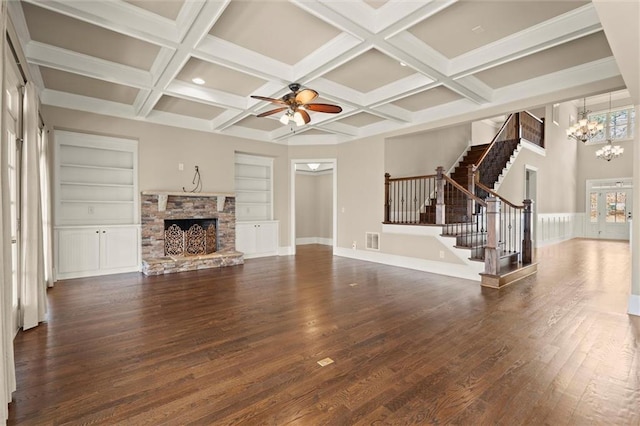 unfurnished living room with a chandelier, stairway, a fireplace, dark wood finished floors, and ceiling fan