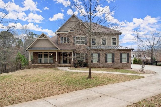 craftsman inspired home with brick siding, a standing seam roof, and covered porch