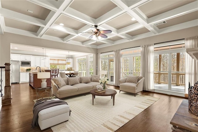 living area with dark wood finished floors, ceiling fan, beam ceiling, coffered ceiling, and recessed lighting