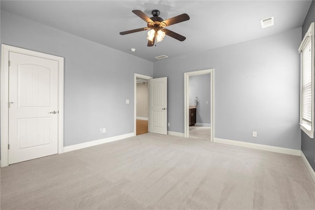 unfurnished bedroom with light colored carpet, baseboards, and ceiling fan