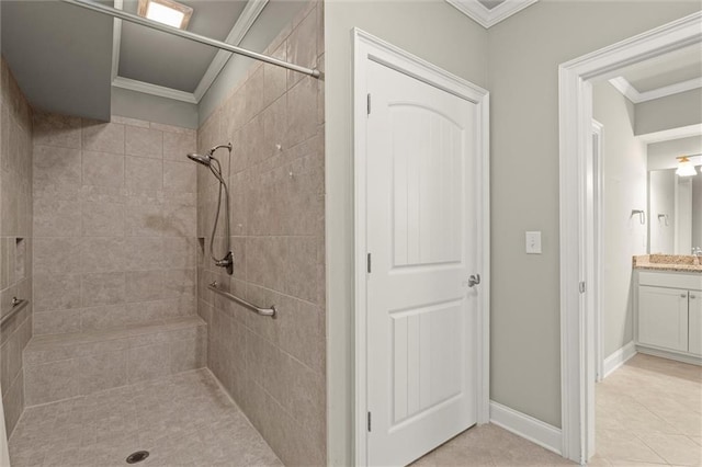 bathroom featuring ornamental molding, tiled shower, tile patterned floors, vanity, and baseboards