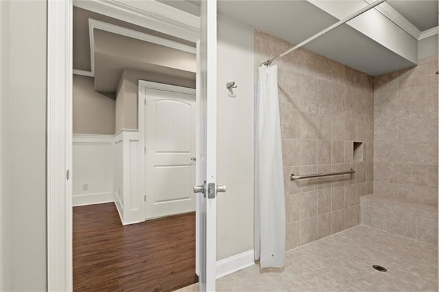 full bath with tiled shower, wood finished floors, and ornamental molding