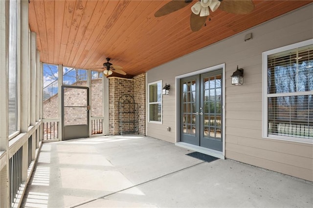 unfurnished sunroom with a ceiling fan and french doors