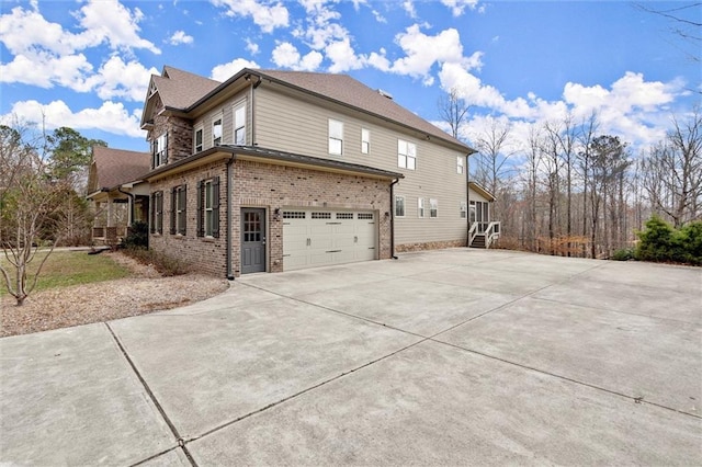 view of home's exterior featuring brick siding, driveway, and a garage