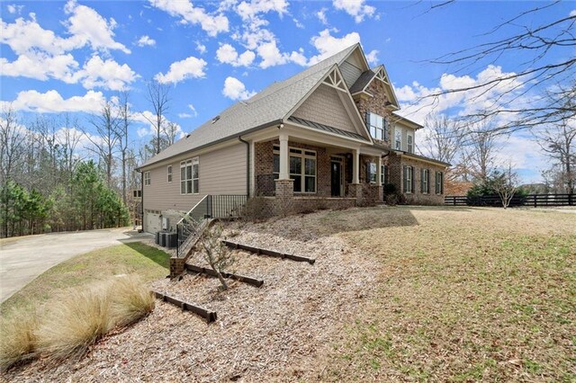view of front of property featuring driveway, fence, brick siding, an attached garage, and roof with shingles