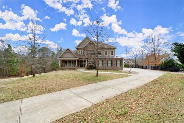 craftsman inspired home featuring brick siding, driveway, and covered porch
