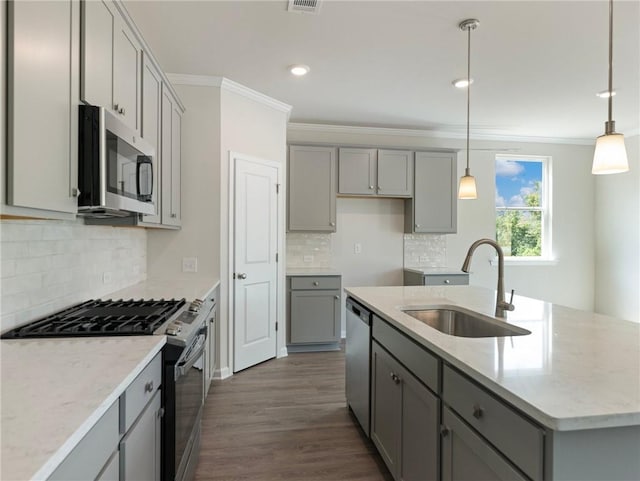 246 W Midland Ave, Winder, GA 30680 - kitchen with gray cabinetry, stainless steel appliances, a sink, ornamental molding, and a kitchen island with sink