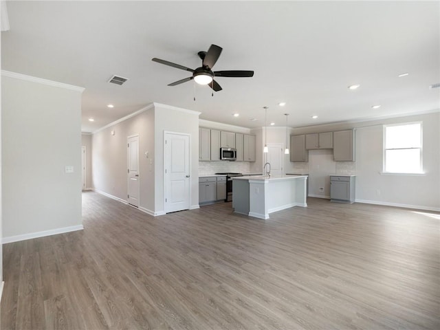 246 W Midland Ave, Winder, GA 30680 - unfurnished living room with crown molding, a ceiling fan, baseboards, light wood-type flooring, and recessed lighting