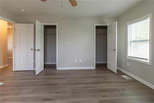 3821 Paul Samuel Rd NW, Kennesaw, GA 30152 - unfurnished bedroom with wood finished floors, baseboards, visible vents, and multiple closets