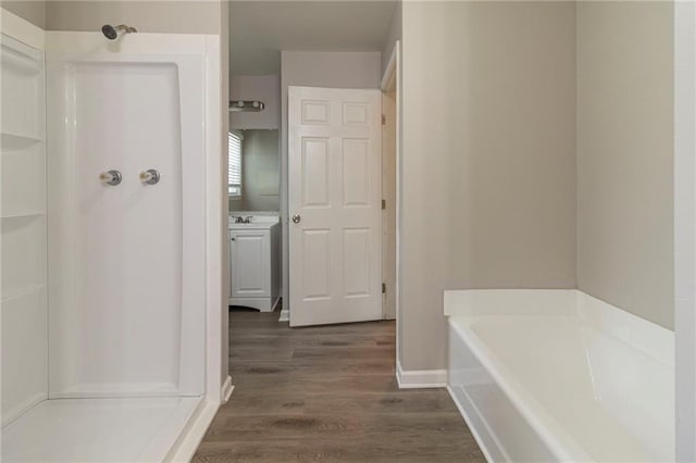 3821 Paul Samuel Rd NW, Kennesaw, GA 30152 - bathroom with vanity, baseboards, a stall shower, a garden tub, and wood finished floors