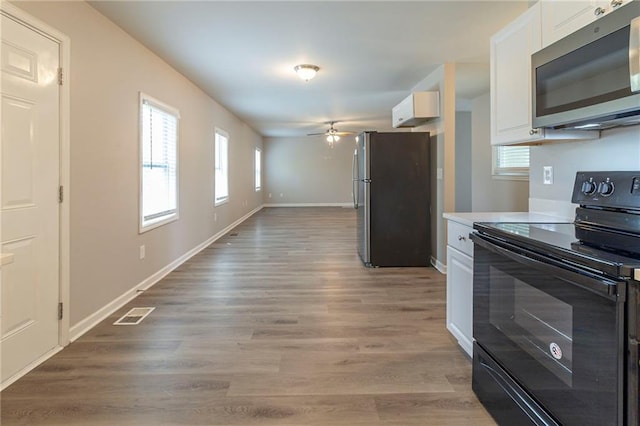 3821 Paul Samuel Rd NW, Kennesaw, GA 30152 - kitchen with baseboards, light wood-type flooring, a ceiling fan, white cabinets, and stainless steel appliances