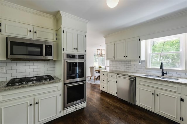 3707 Dunwoody Club Dr, Atlanta, GA 30350 - kitchen with appliances with stainless steel finishes, a sink, dark wood finished floors, tasteful backsplash, and crown molding